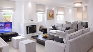 A modern living room with a fireplace, a television, and a sofa set.