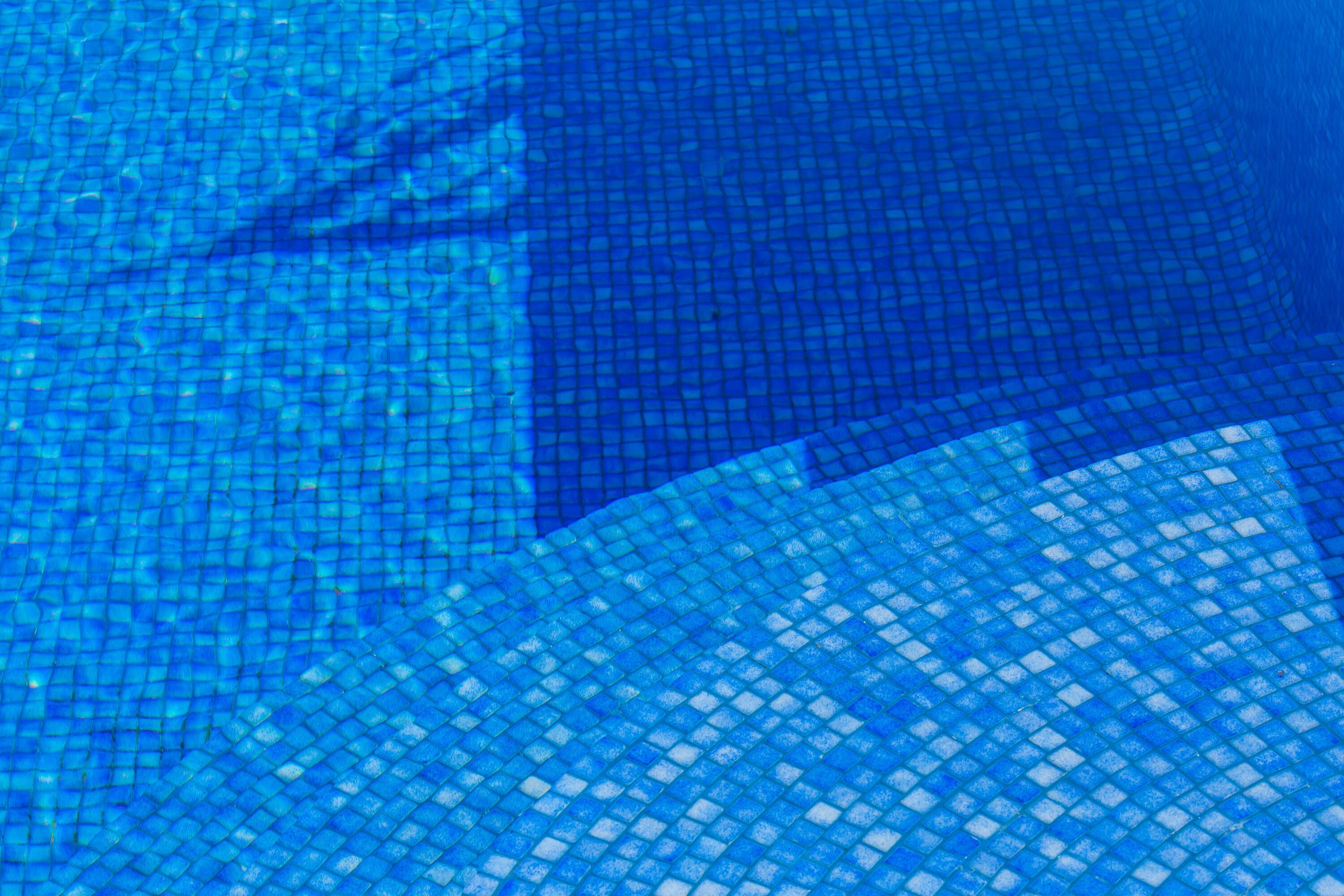 Un gros plan d’une piscine aux carreaux bleus disposés en motif quadrillé.