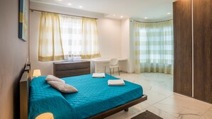 A modern bedroom with a bed, desk, and wardrobe. - Spectacular Sea Front Villa - The Waterfront (Marsaskala)