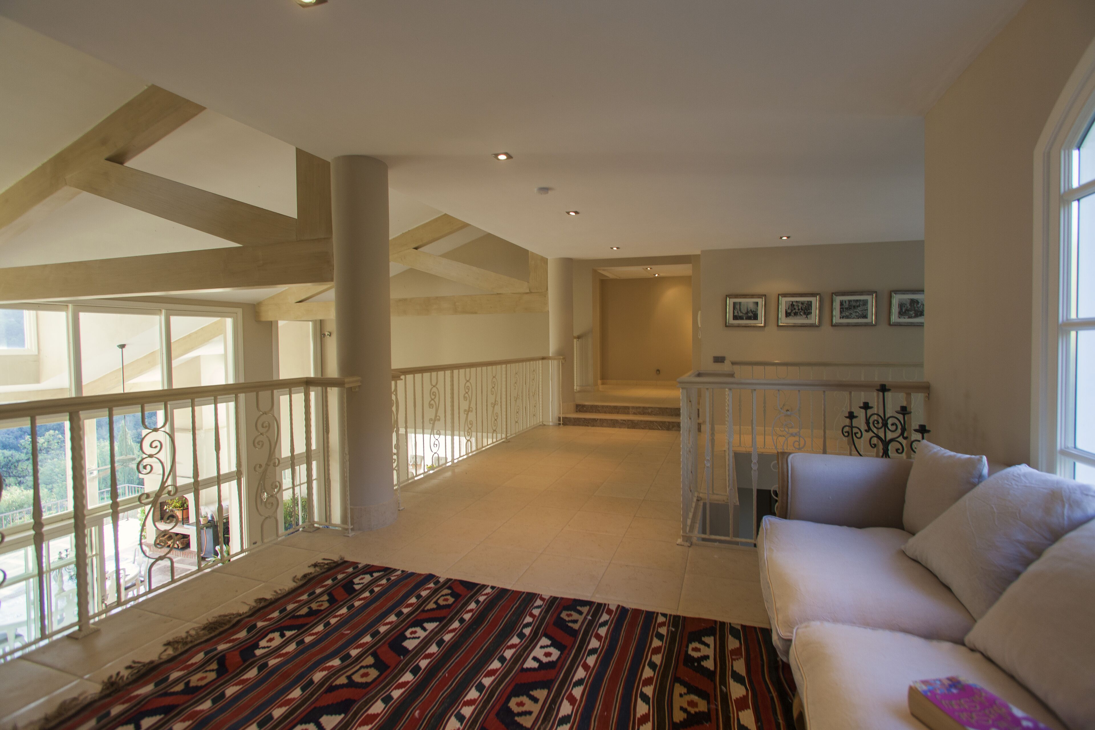 Un vaste espace de vie avec un balcon, un escalier et un canapé.