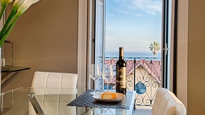 Un balcone con un tavolo, una bottiglia di vino e un piatto con una fetta di pane.