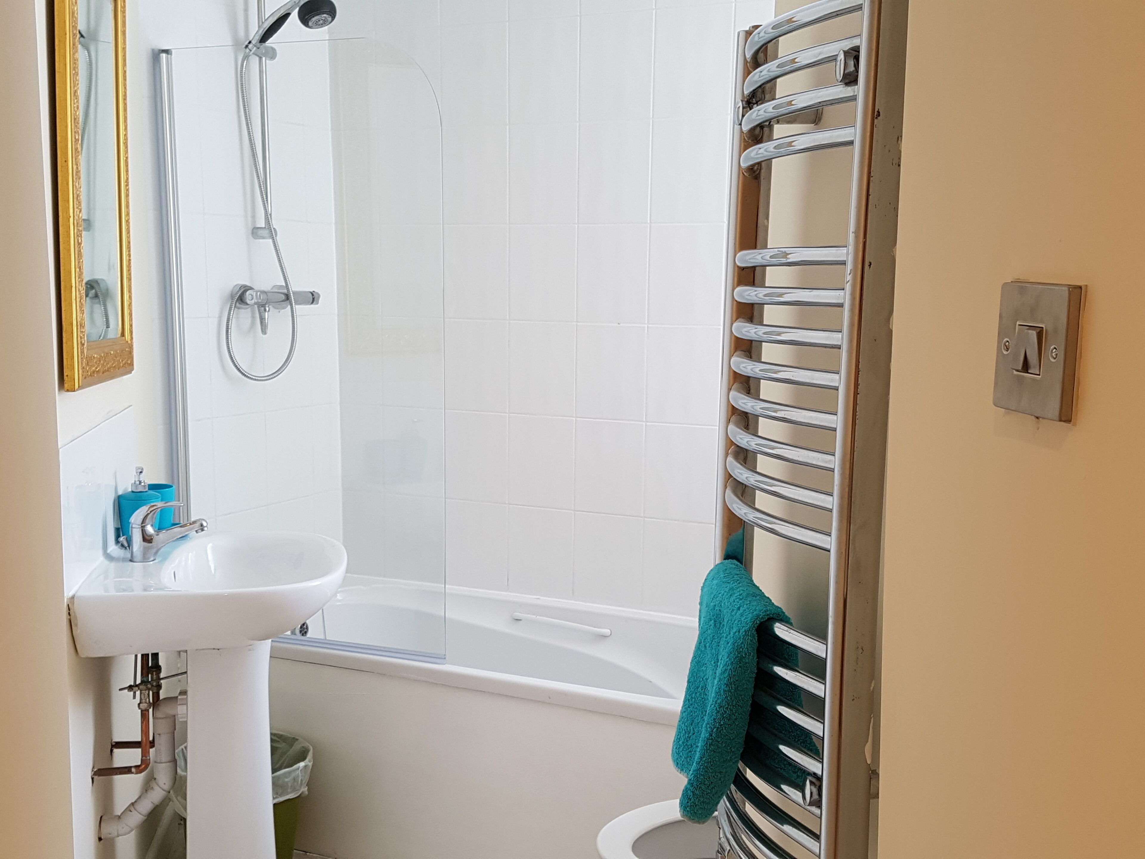 A bathroom with a white bathtub, a sink, and a shower.