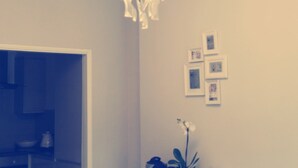 Ein Zimmer mit einer Kandelaber, einer Tür und gerahmten Bildern an der Wand.