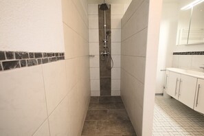 Een bad/douchecombinatie, zeep, toiletpapier