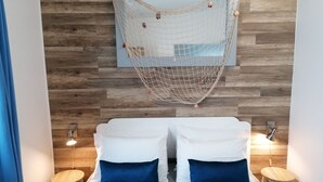 A room with a bed, two nightstands, a hanging net, and wooden wall paneling. - Ilhéu Corner - "Blue and Sea" (Ponta Delgada)
