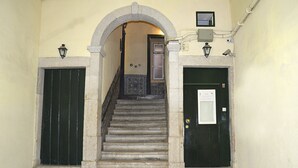 A staircase with a tiled floor leading to a door with a sign. - Cozy Palace in Lisbon for 2 to 6 people (Lisboa)