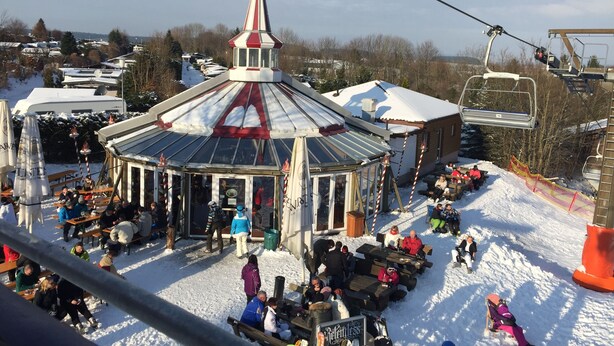 A snow-covered outdoor area with a gazebo, picnic tables, and a ski lift in the background. - Romantic apartment with fantastic views, WiFi free (Winterberg)