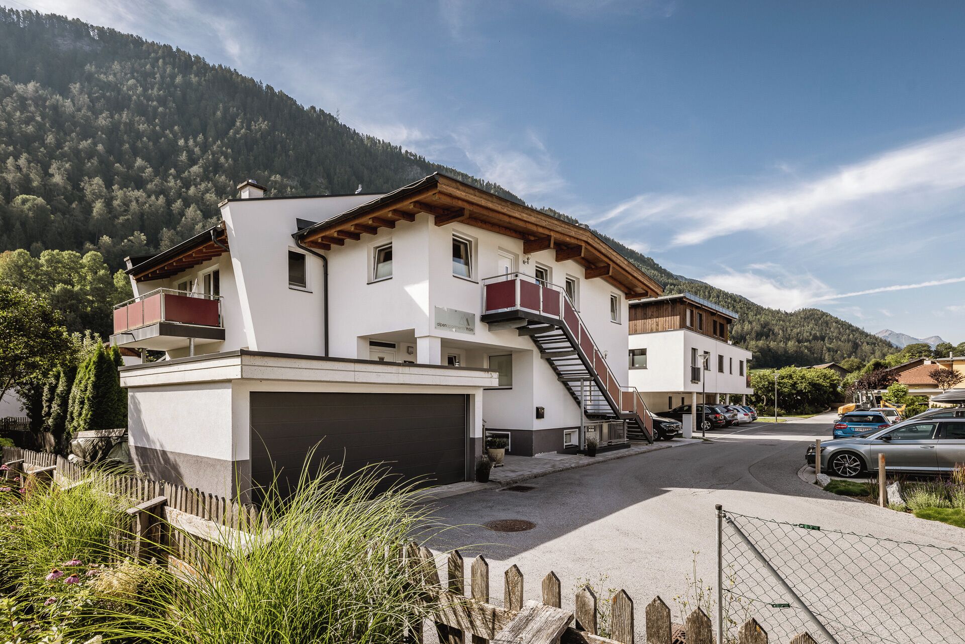 Un bâtiment à deux étages doté d’un garage, d’un escalier et d’un balcon.