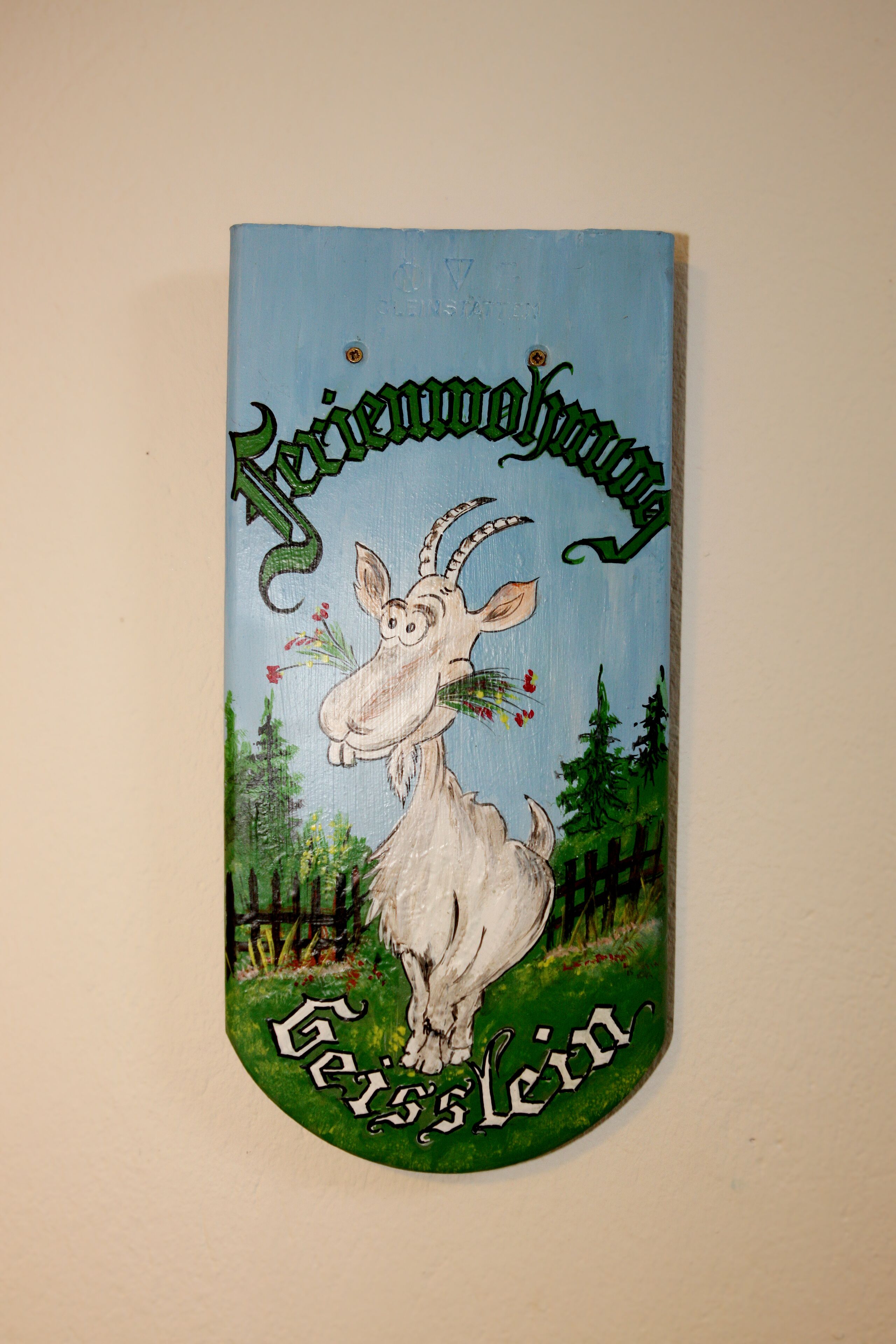 Une plaque en bois ornée d’une illustration de chèvre et portant les inscriptions « Jägerwoof » et « Gösslein ».