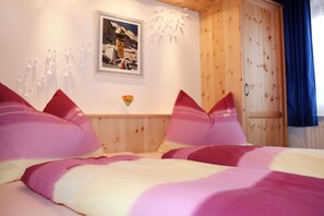 Une chambre à coucher avec une tête de lit en bois, un tableau encadré au mur et une porte avec un rideau.