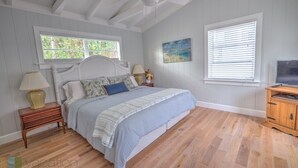 A bedroom with a bed, nightstands, a TV stand, and a ceiling fan. - Beachy Perfection - Walk to Atlantic Ave. (Delray Beach)