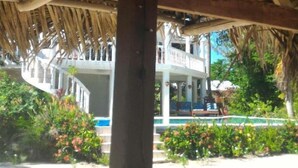 A thatched roof structure with a sign reading "PHILVILLE THE SAUMS". -  Beachfront Private Pool Home  -  A "Gold Standard Facility" (Placencia)