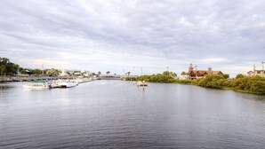 Un río tranquilo con un muelle y un edificio con una torre a la derecha.