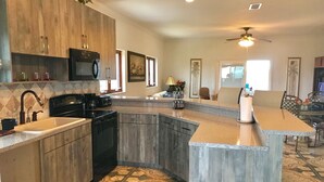A modern kitchen with granite countertops, wooden cabinets, and a built-in dishwasher.