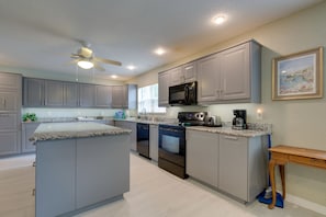 Enjoy cooking in this well-equipped kitchen with a central island, microwave, oven, and coffee maker.