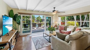 A spacious living room with a large sliding glass door leading to a patio area. - Charming Florida Home on the Waterway with Coastal Charm and Easy, Relaxed Vacation Vibes! (Wilton Manors)