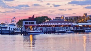 Ein Yachthafen mit vertäuten Booten, ein Restaurant mit Außenbereich und ein Gebäude mit rotem Dach.