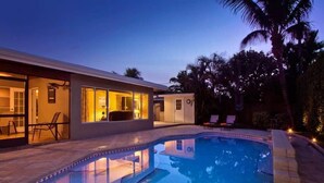 Ein modernes Haus mit Pool, Außenbereich und einer gut beleuchteten Eingangsparte.