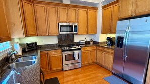 A kitchen with wooden cabinets, a stainless steel refrigerator, a microwave, an oven, and a sink. - 3 Bedroom 3 Bath Ocean Views Rooftop Deck Sleeps 8 (Jacksonville Beach)