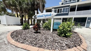 A sign for 'Island Splash' with a building in the background.
