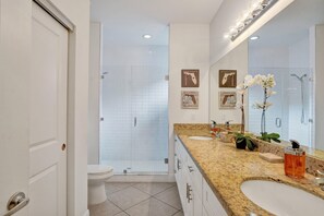 A modern bathroom with a walk-in shower, a large mirror, and a granite countertop. - Coral Reef Villa 🌴 Private Heated Pool, Grill, Private Patio | 1.9 mi to Beach 🏖️ (Oakland Park)