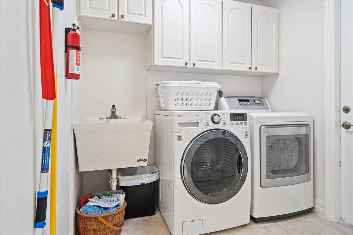 A laundry room with a washing machine, dryer, and a sink.