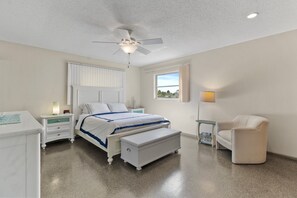A bedroom with a bed, a nightstand, a chair, a window, and a ceiling fan. - Enjoy the Warm Mineral Springs Vacation Rental Home of North Port, Florida (North Port)