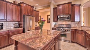 A kitchen with wooden cabinets, stainless steel appliances, and a granite countertop. - Riverfront Titusville Home w/ Pool + Pickleball! (Titusville)