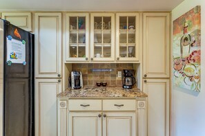 A kitchen with a refrigerator, coffee maker, and cabinets. - 3 Mi to Beach: Prime Largo Home w/ Pool! (Largo)