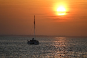 A sailboat on calm water during sunset.