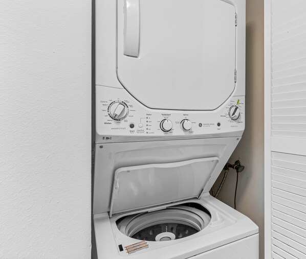 Een wasmachine met voorlaadopening, bedieningsknoppen en een zeepbakje.