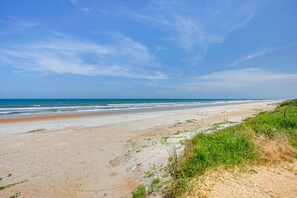 Een strand met een heldere lucht en oceaan.