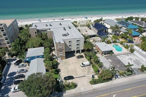 Ein Hotel mit Dachpool, Parkplatz und Blick auf den Strand.