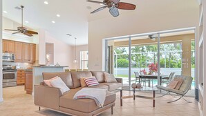 A modern living room with a sofa, coffee table, and a dining area with chairs.
