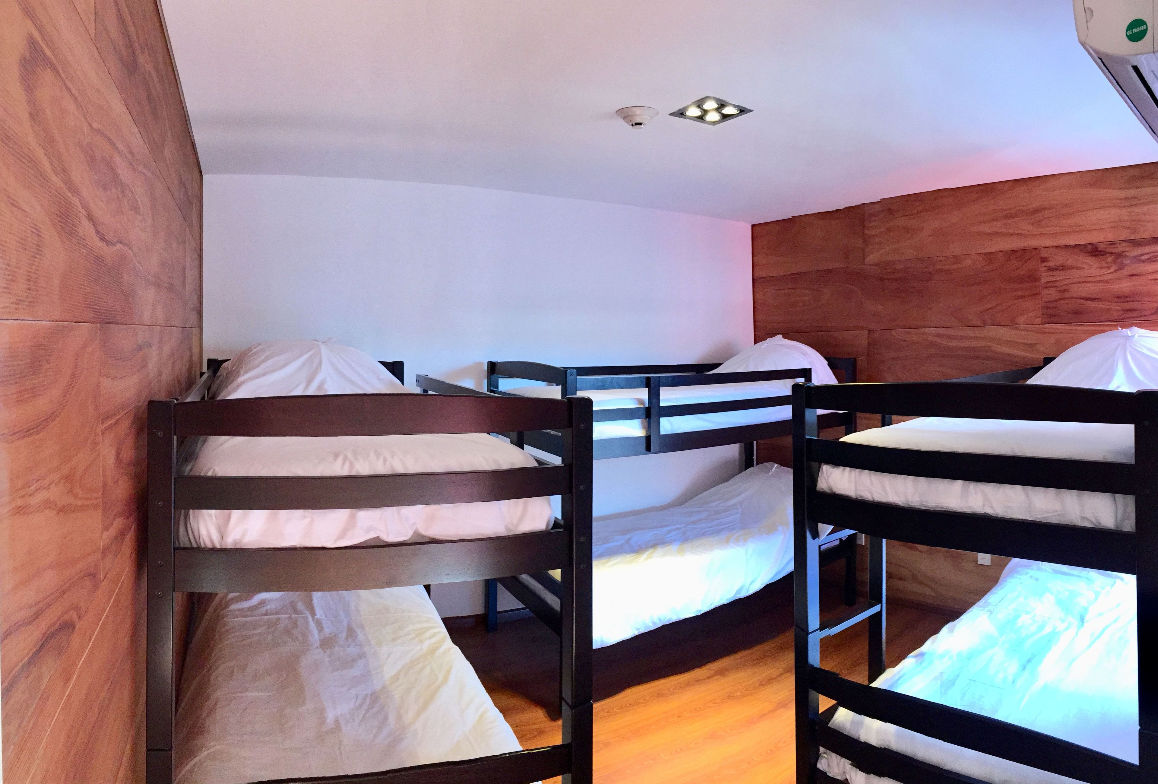A bunk bed room with wooden walls and a ceiling light fixture.