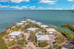 A resort with multiple buildings, a swimming pool, and a dock extending into the water. - Gulf Pointe Paradise (Marathon)