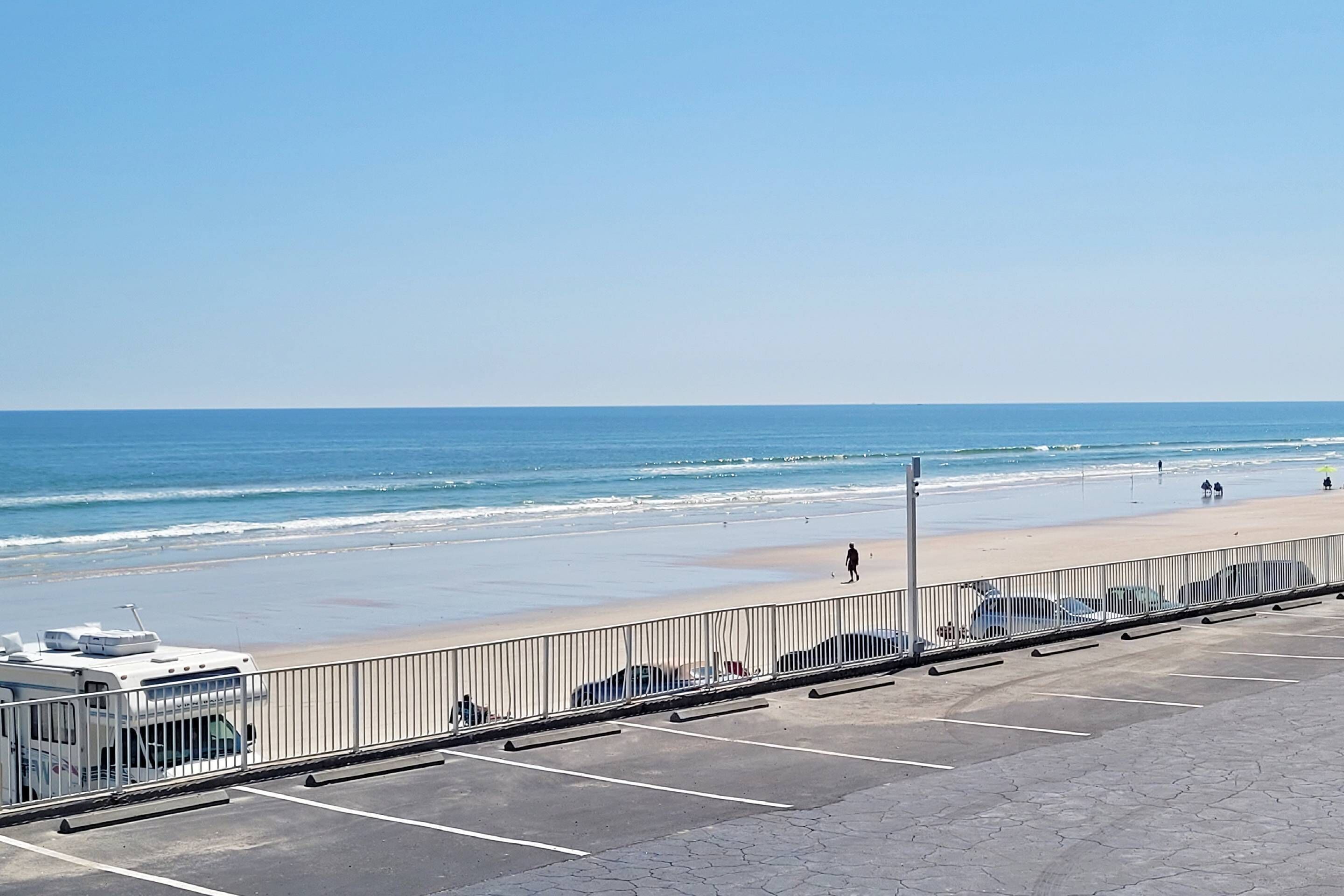 A parking area with a view of the beach and ocean.