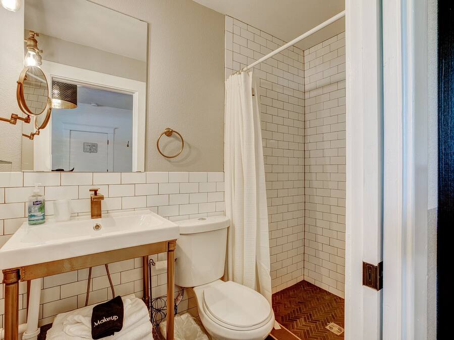 A bathroom with a white sink, toilet, and shower curtain.