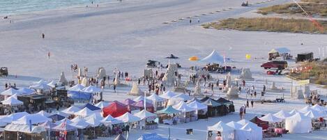 A beach with tents and people, likely a market or event.