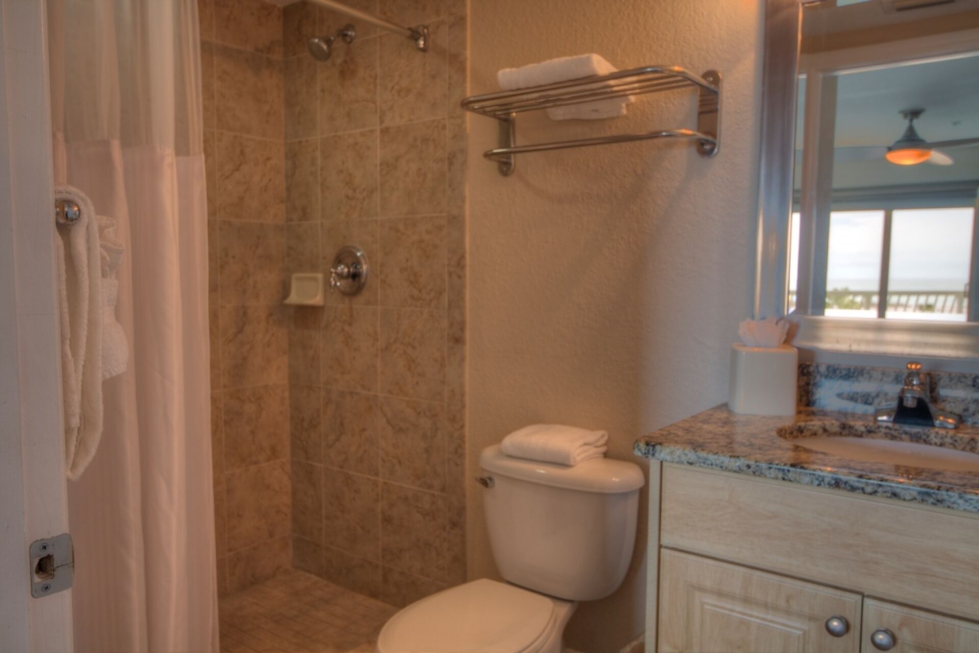 A bathroom with a shower, toilet, and vanity.