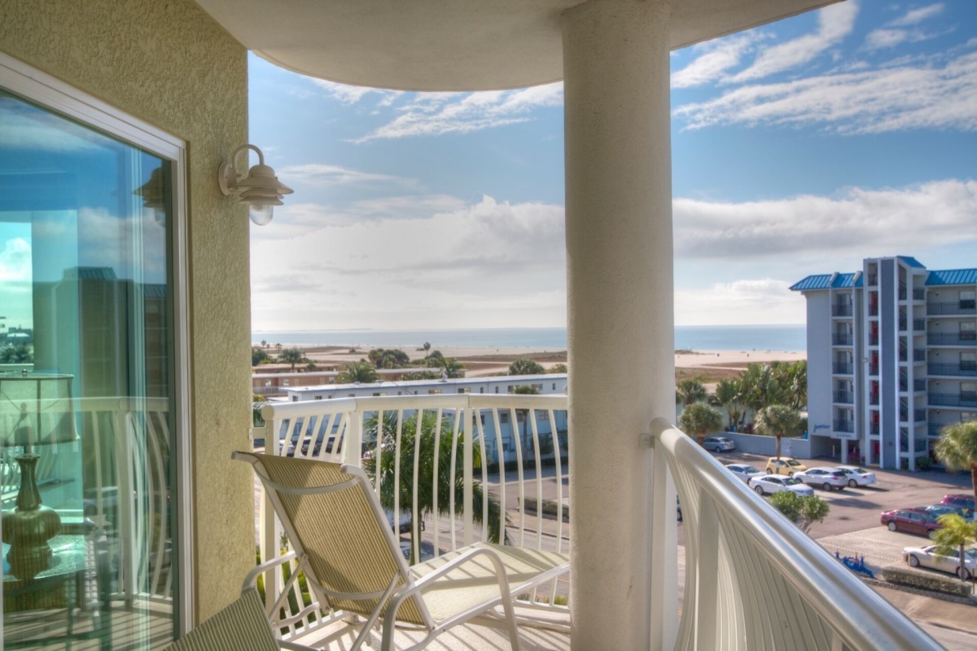 Ein Balkon mit Blick auf Strand und Parkplatz.