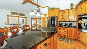 Una cocina amplia con armarios de madera, una isla central y un refrigerador de acero inoxidable.