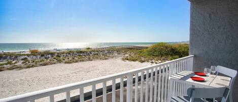 Ein Balkon mit Blick auf Strand und Meer.