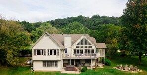 Une maison à deux étages avec un balcon, un garage et une pelouse bien entretenue.
