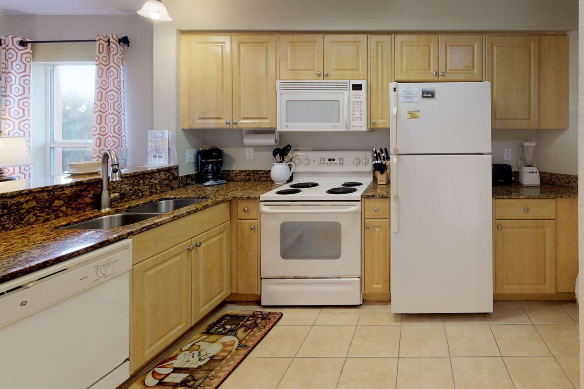 Una cocina con armarios de madera, una estufa blanca, un microondas y un refrigerador.
