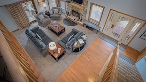A spacious living room with a fireplace, multiple seating areas, and a view of the outdoors.