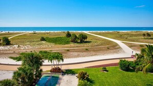 A beachfront property with a clear view of the ocean, a walking path, and a well-maintained lawn. - Modern 2Br/2Ba Beachfront Condo with an Incredible View. Amenities, Pool, Beautiful Beach (Treasure Island)