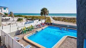 Una piscina con lettini e vista sulla spiaggia.