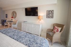 Une chambre à coucher avec un lit, une télévision, une commode et une chaise.