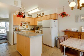 Enjoy meal preparation and dining in this kitchen with a central island, microwave, and stainless steel refrigerator.